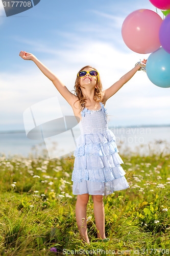 Image of happy girl waving hands with colorful balloons