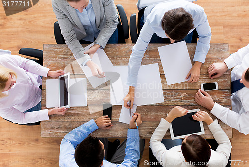 Image of close up of business team with papers and gadgets