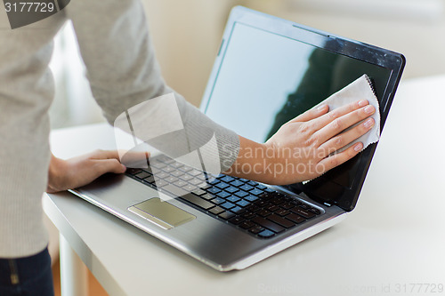 Image of close up of woman hands cleaning laptop screen