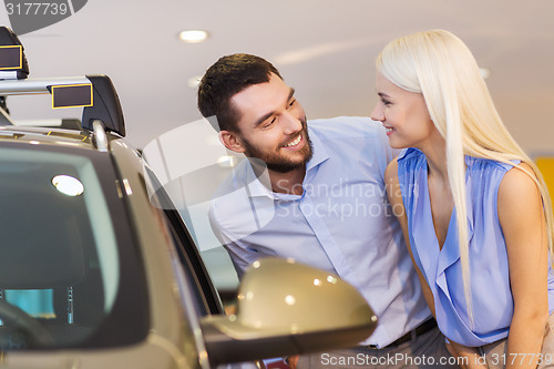 Image of happy couple buying car in auto show or salon