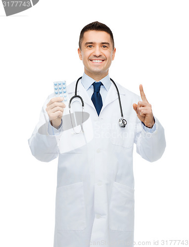 Image of smiling male doctor in white coat with tablets