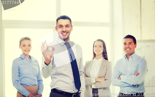 Image of smiling businessman showing ok-sign in office