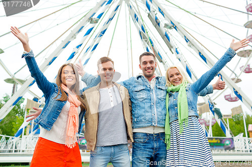 Image of group of smiling friends waving hands