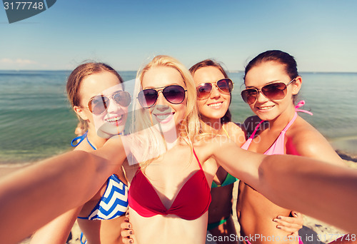 Image of group of young smiling women making selfie