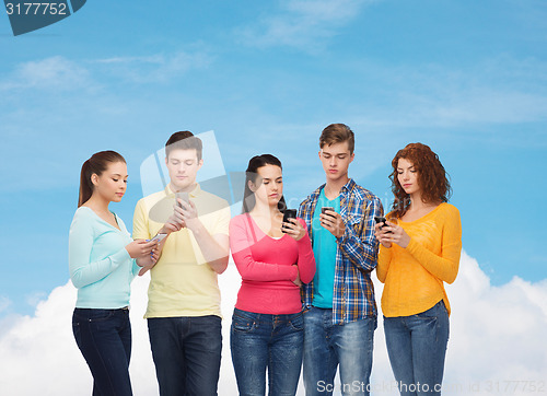 Image of group of serious teenagers with smartphones