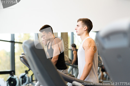 Image of group of men exercising on treadmill in gym