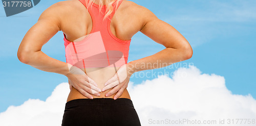 Image of close up of sporty woman touching her back