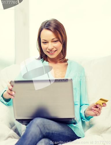 Image of smiling woman with laptop computer at home