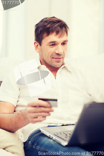 Image of man with laptop and credit card at home