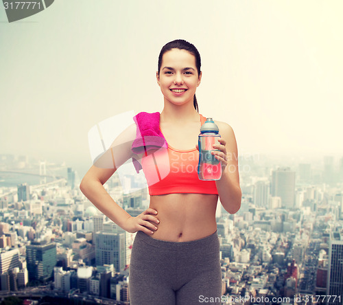 Image of sporty woman with towel and water bottle