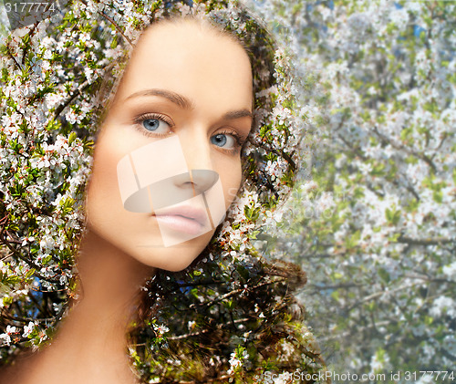 Image of young woman over blooming tree pattern