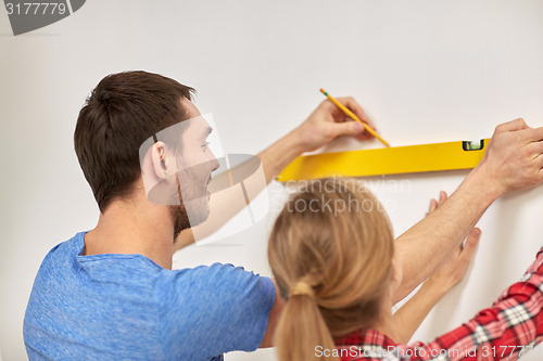 Image of close up of couple with level measuring wall