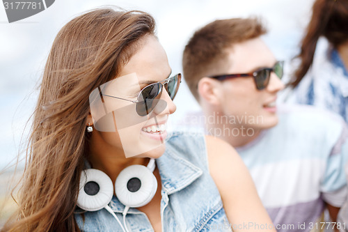 Image of smiling teenage girl outdoors with friends