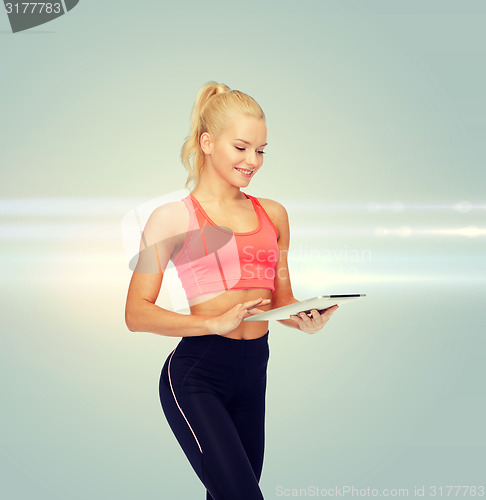 Image of smiling sporty woman with tablet pc computer