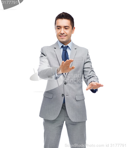 Image of happy businessman in suit touching something