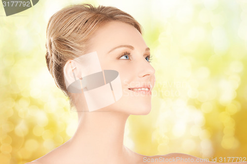 Image of beautiful young woman face over yellow background