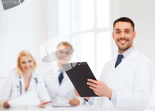 Image of smiling male doctor with clipboard