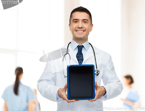 Image of smiling male doctor with tablet pc at hospital