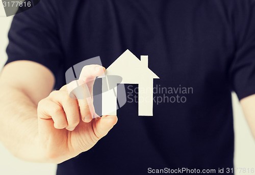 Image of man hand holding paper house