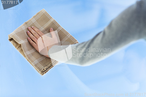 Image of close up of woman hand cleaning window with cloth