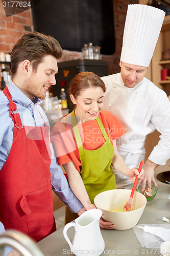 Image of happy couple and male chef cook cooking in kitchen