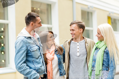 Image of group of smiling friends walking in the city