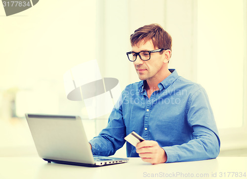 Image of man with laptop and credit card at home
