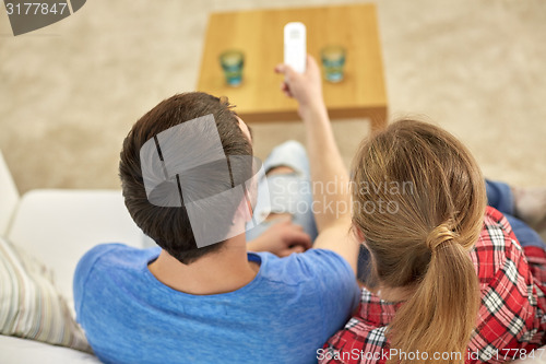 Image of close up of couple with remote watching tv at home