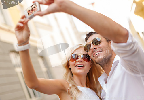 Image of travelling couple taking photo picture with camera