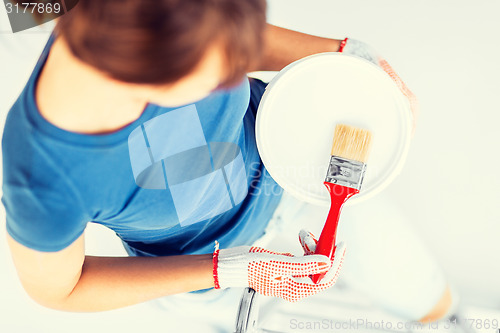 Image of woman with paintbrush and paint pot