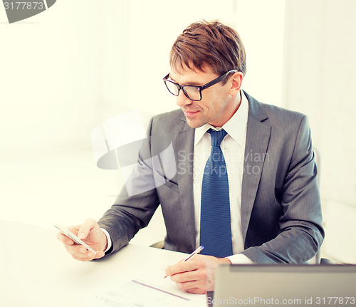Image of businessman working with laptop and smartphone