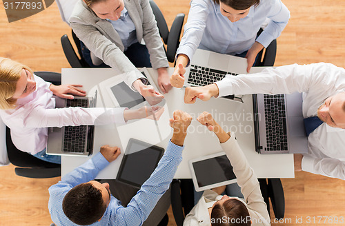 Image of business team showing thumbs up