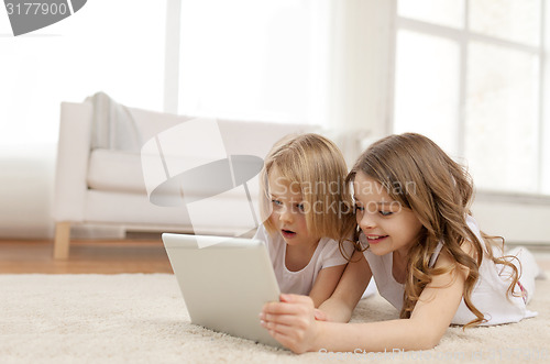 Image of two little girls with tablet pc at home