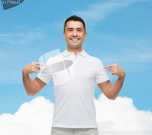 Image of smiling man in t-shirt pointing fingers on himself