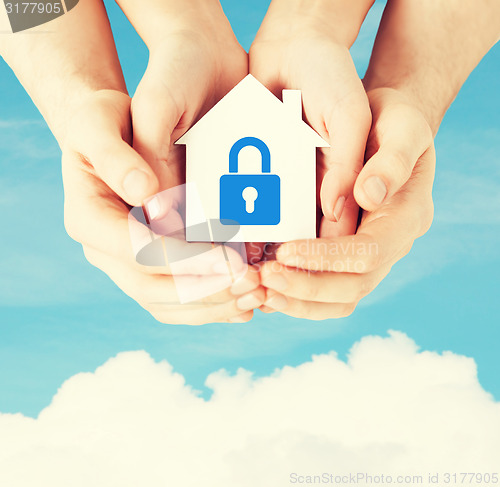 Image of hands holding paper house with lock