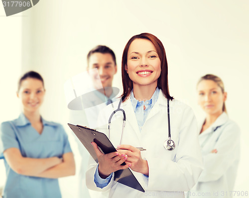 Image of smiling female doctor with clipboard