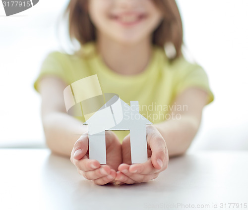 Image of close up of happy girl hands holding paper house