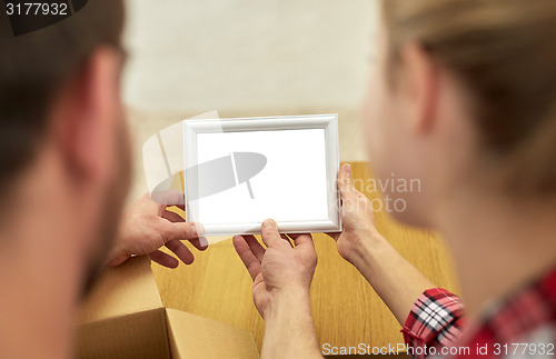 Image of close up of happy couple looking at family photo