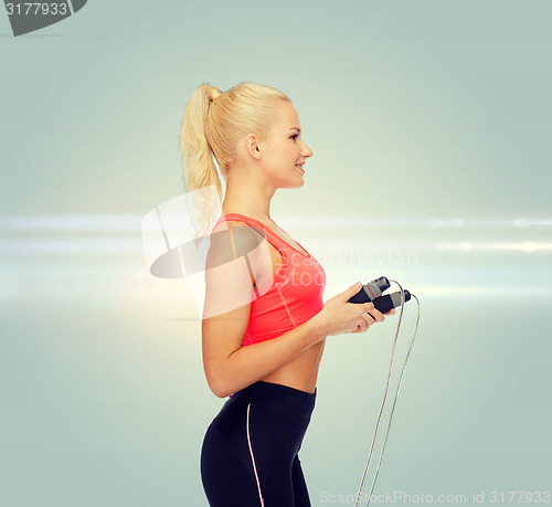 Image of smiling sporty woman with skipping rope