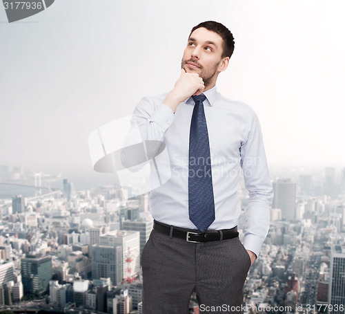 Image of handsome businessman looking up