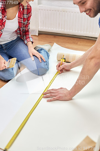 Image of close up of happy couple measuring wallpaper