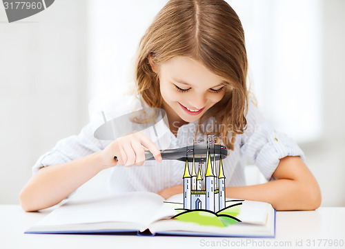 Image of girl with book looking to castle through magnifier