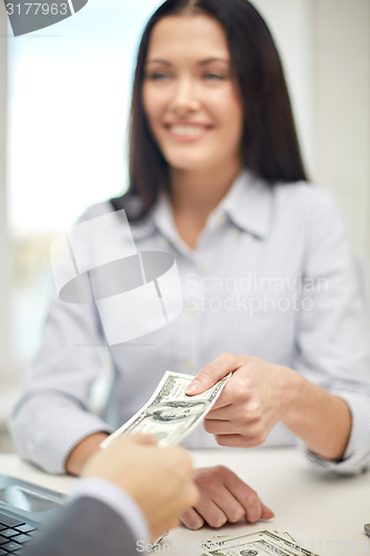 Image of close up of happy woman giving or exchanging money