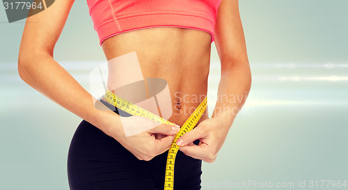 Image of close up of female hands measuring waist