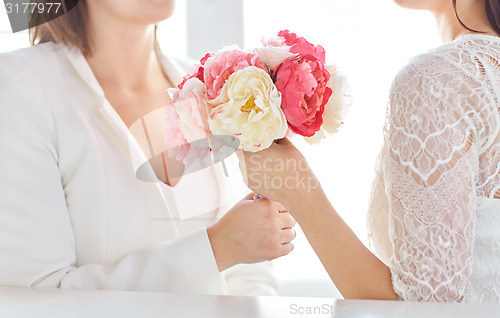 Image of close up of happy lesbian couple with flowers