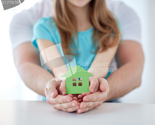 Image of close up of man and girl hands with paper house