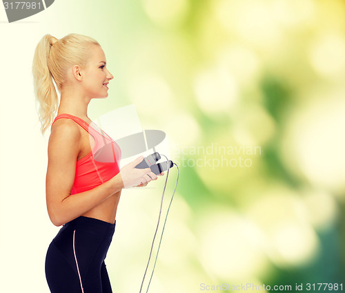 Image of smiling sporty woman with skipping rope