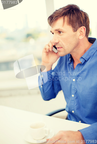 Image of businessman with cell phone and cup of coffee