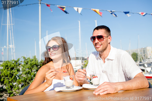 Image of smiling couple eating dessert at cafe