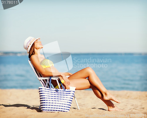 Image of girl sunbathing on the beach chair